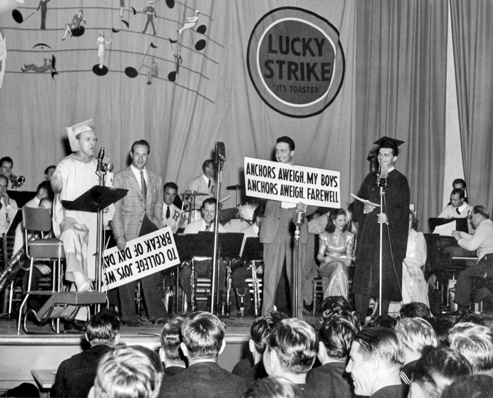 Kay Kyser (in cap and gown) and his band entertain U.S. Navy personnel during a live NBC radio broadcast of Kay Kyser's Kollege of Musical Knowledge, ca. 1943. North Carolina Collection, University of North Carolina at Chapel Hill Library.