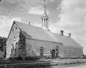 A small chapel sits beside a road. 